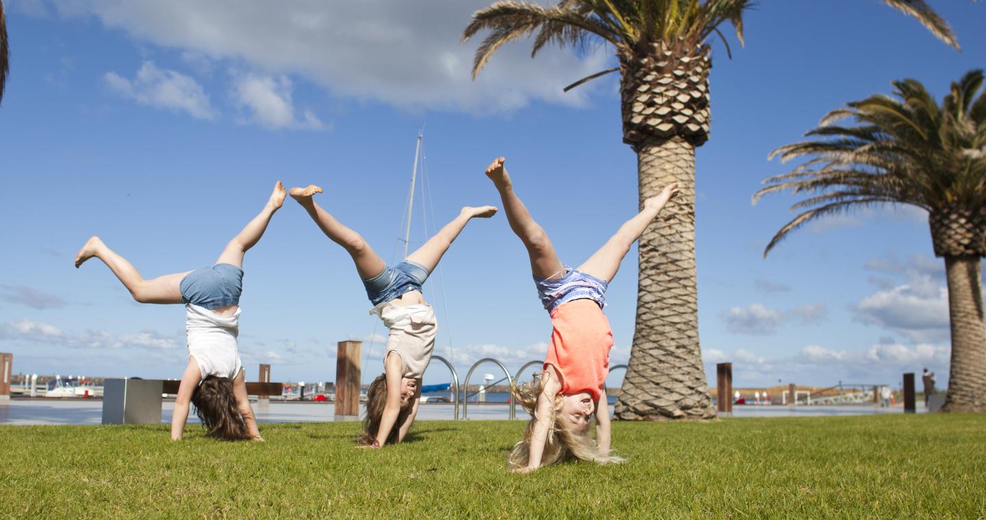 Children playing at Wyndham Harbour on grass