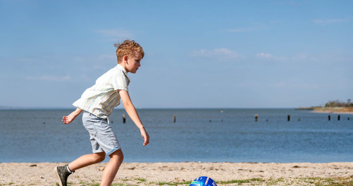 child with a ball on beach