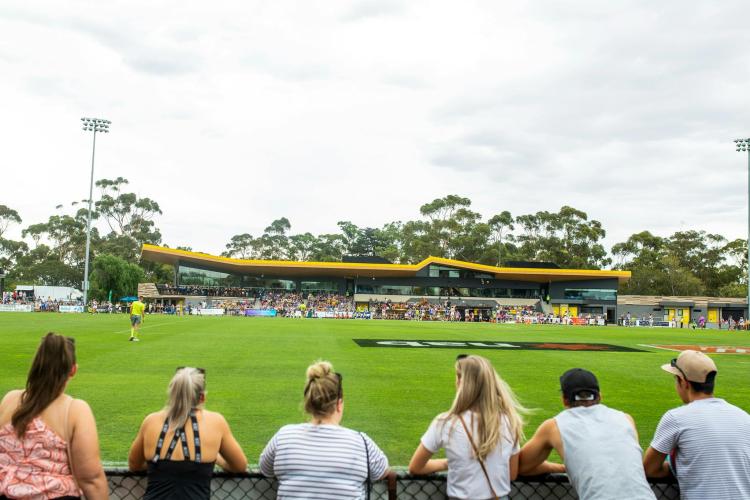 people standing at fence watching Australian Rules Football at Chrinside Park