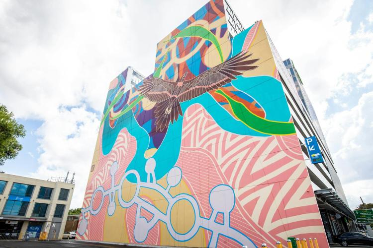 A large Indigenous mural featuring Bunjil on a building facade