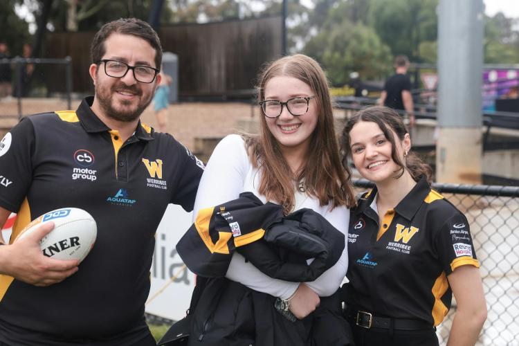 coaches and fan holding Werribee Football Club jacket smiling to camera