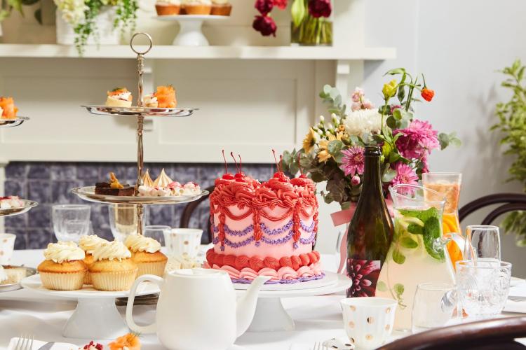 High tea set up with cakes, treats and mixed drinks