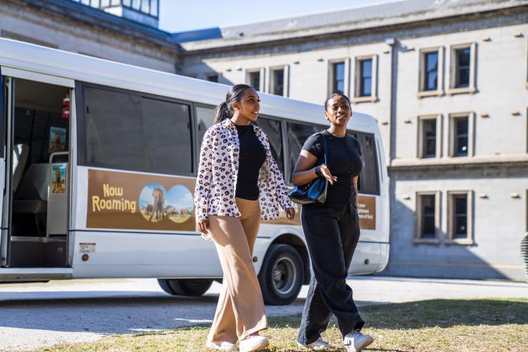 two adults walking in front of Visitor Shuttle Bus at Lancemore Mansion Hotel