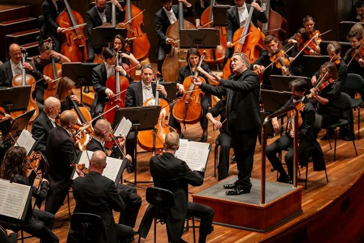 Orchestra performing on stage with conductor