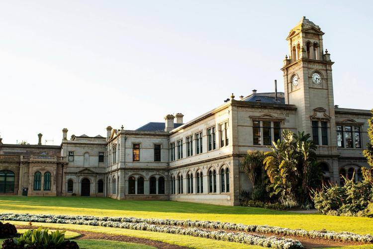 exterior of Lancemore Mansion Hotel Werribee Park with green lawns and flowers in front