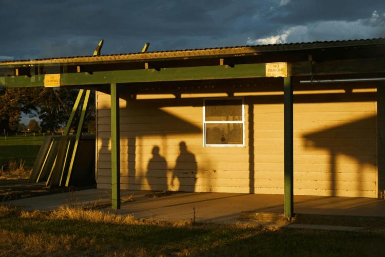 shadows of people against a building during daylight