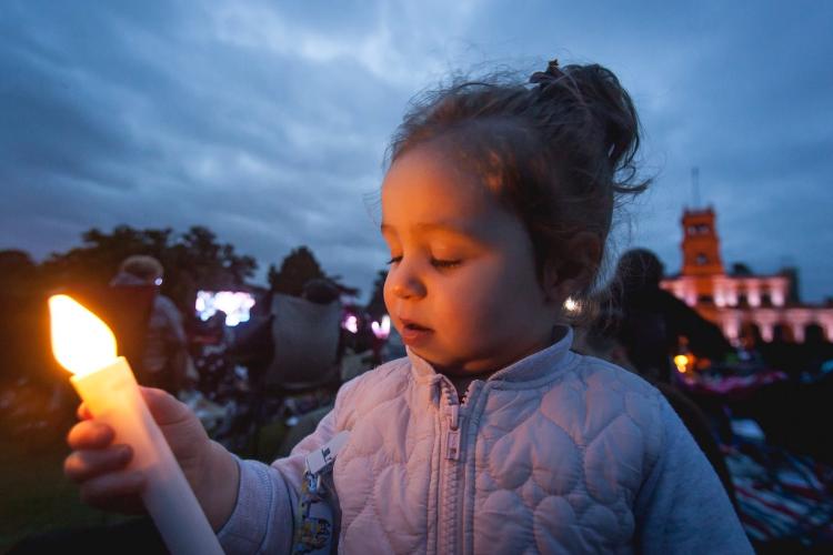 young girl at dusk holding battery operated candle