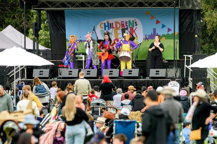 crowd watching performers on stage at the Children's Week Picnic