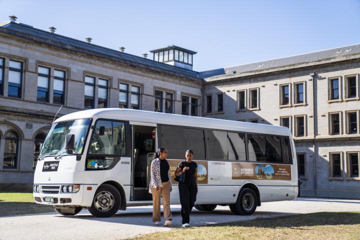 two adults walking in front of Visitor Shuttle Bus at Lancemore Mansion Hotel