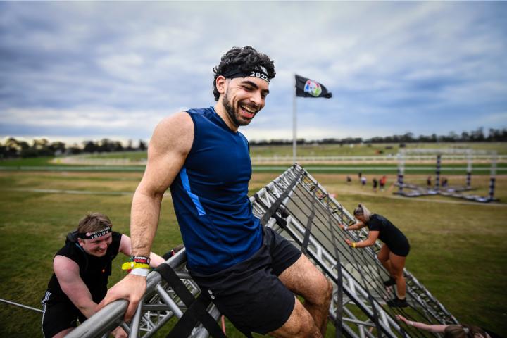 man smiling while climbing structure